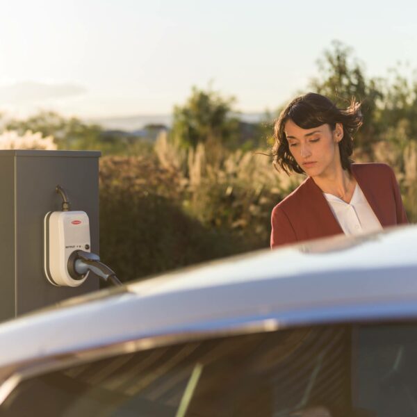 Caucasian brunette charging an electric vehicle from a 1st Generation Fronius Wattpilot EV Charger