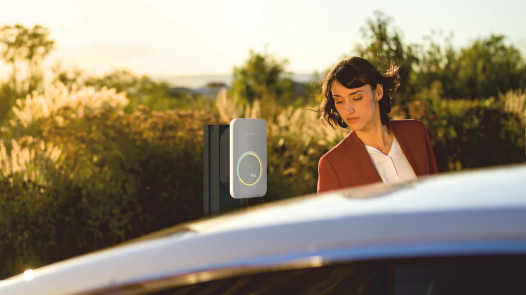 Person near Fronius Wattpilot Flex electric vehicle charger.
