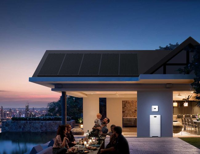 Happy family outside a home at dusk with a Huawei LUNA2000 solar battery providing energy to the home illustrated with the house lights on.